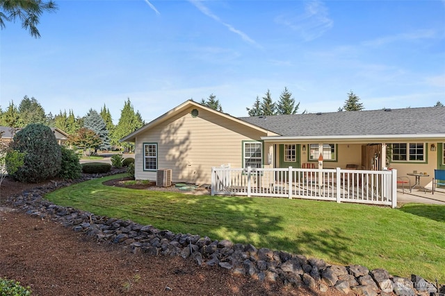 back of house featuring a lawn, a patio area, and central AC