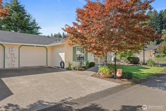 view of front of home featuring a garage, aphalt driveway, and a front yard