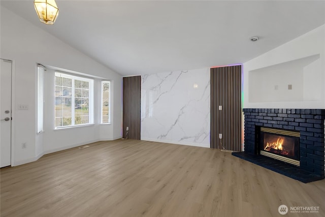 22516 45th Ave E, Spanaway, WA 98387 - unfurnished living room featuring baseboards, wood finished floors, lofted ceiling, and a fireplace