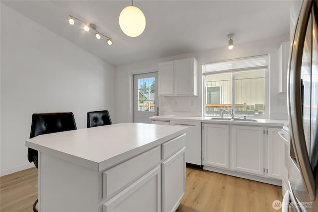 22516 45th Ave E, Spanaway, WA 98387 - kitchen with white dishwasher, stainless steel fridge, a sink, light wood finished floors, and light countertops