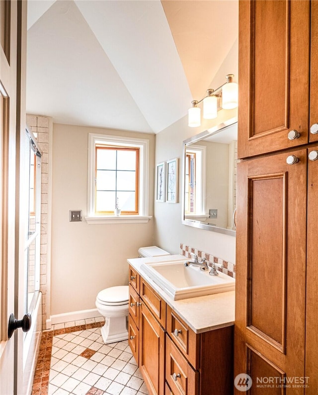 8314 Island Dr S, Seattle, WA 98118 - full bath with vaulted ceiling, vanity, tile patterned floors, baseboards, and toilet