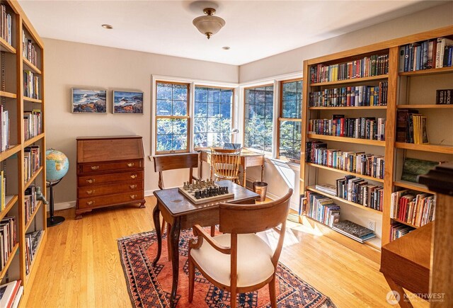 8314 Island Dr S, Seattle, WA 98118 - office area featuring baseboards, bookshelves, and wood finished floors
