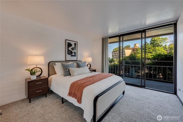 9500 Rainier Ave S Unit 102, Seattle, WA 98118 - bedroom featuring a wall of windows, light carpet, and access to exterior