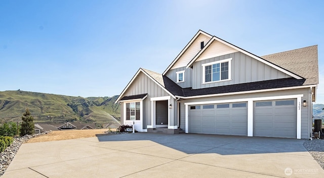 1502 S Kelvin Ct, East Wenatchee, WA 98802 - view of front of house with board and batten siding, concrete driveway, a mountain view, a shingled roof, and a garage
