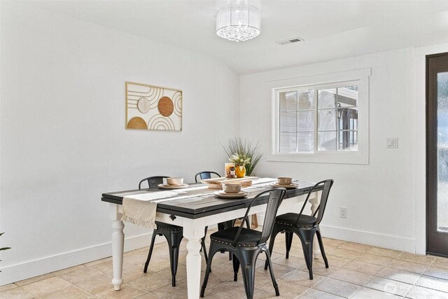 dining area with an inviting chandelier, light tile patterned flooring, baseboards, and visible vents