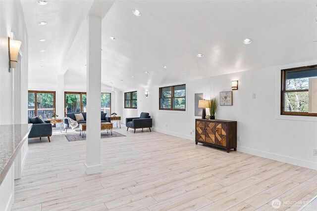 interior space featuring lofted ceiling, baseboards, recessed lighting, and light wood-style floors