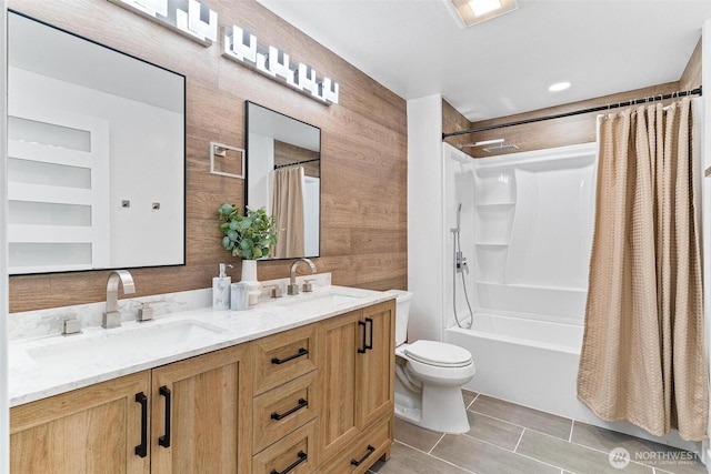 bathroom featuring double vanity, toilet, shower / bathtub combination with curtain, and a sink