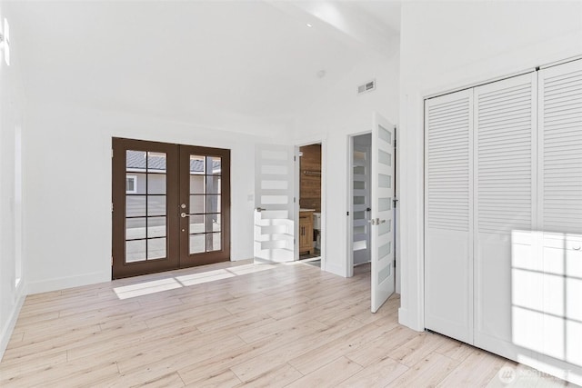 unfurnished bedroom with wood finished floors, french doors, a closet, visible vents, and beamed ceiling