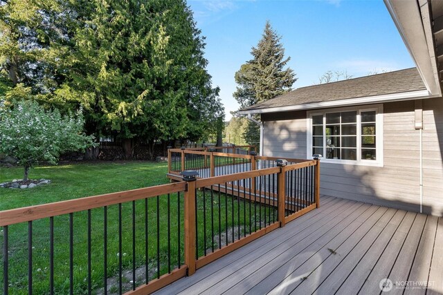 deck with a lawn and a fenced backyard