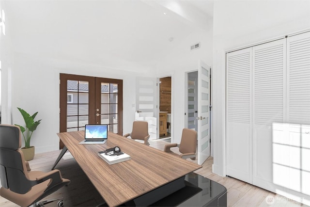 office space featuring visible vents, french doors, lofted ceiling with beams, and light wood-style flooring