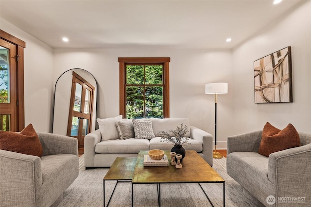 living area with recessed lighting, baseboards, and light wood-type flooring