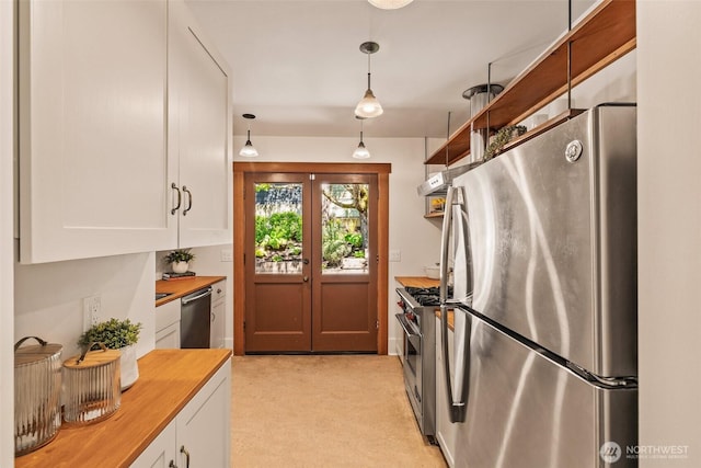 kitchen featuring wood counters, white cabinets, stainless steel appliances, and light colored carpet