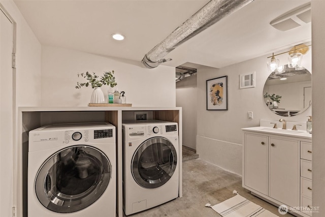 laundry room with visible vents, a sink, washing machine and dryer, and laundry area