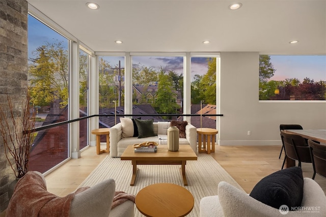 sunroom featuring baseboards, recessed lighting, wood finished floors, and expansive windows