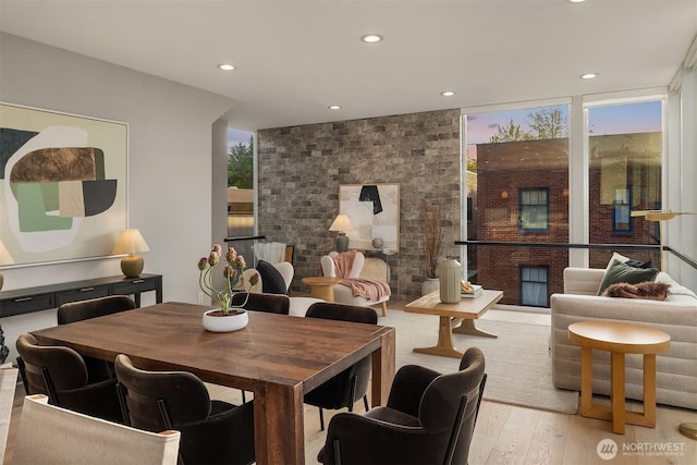 dining room featuring a wall of windows, recessed lighting, and wood finished floors