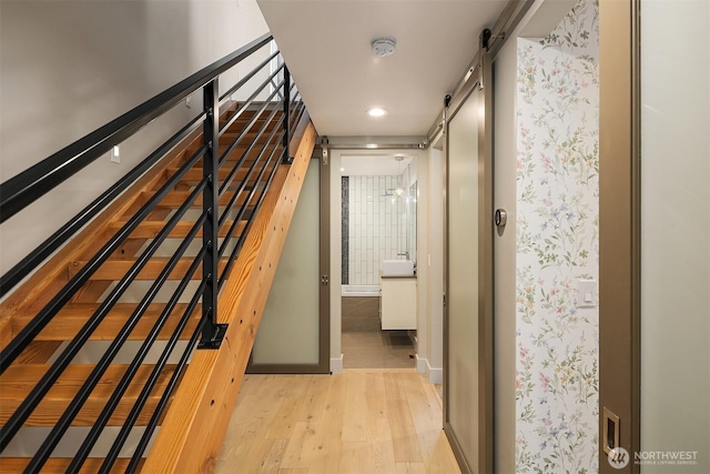 stairs with baseboards, recessed lighting, a barn door, and wood finished floors
