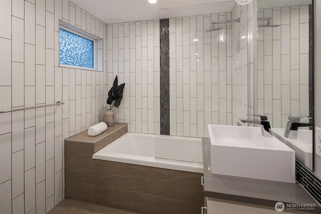 bathroom featuring vanity, tiled shower / bath combo, and tile walls
