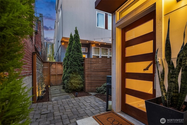 property exterior at dusk featuring fence