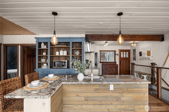 23821 S Lake Roesiger Rd, Snohomish, WA 98290 - kitchen with pendant lighting, wood finished floors, light stone countertops, stainless steel microwave, and a sink