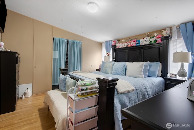 bedroom featuring light wood-type flooring and vaulted ceiling