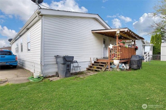 rear view of property featuring a lawn and fence