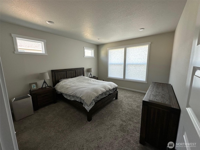 carpeted bedroom featuring baseboards and a textured ceiling
