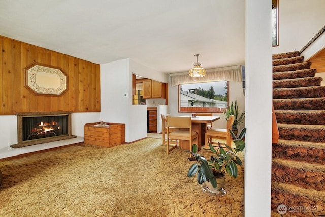 4995 Johnson St NW, Bremerton, WA 98311 - dining space featuring stairway, carpet floors, a lit fireplace, and wood walls