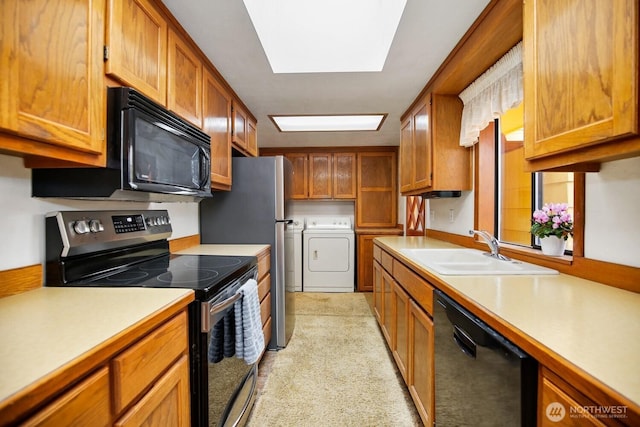 4995 Johnson St NW, Bremerton, WA 98311 - kitchen featuring black appliances, washing machine and dryer, a sink, and brown cabinetry