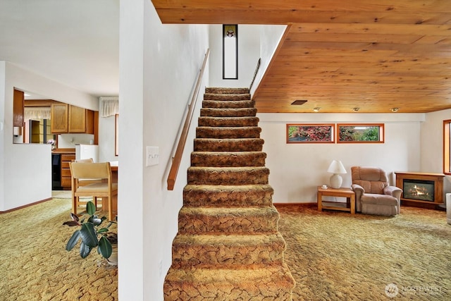 4995 Johnson St NW, Bremerton, WA 98311 - staircase featuring carpet floors, a glass covered fireplace, and wooden ceiling