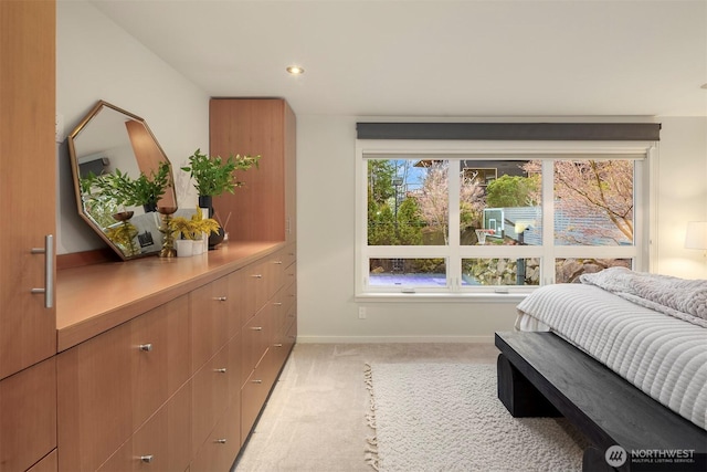 bedroom with baseboards and light colored carpet