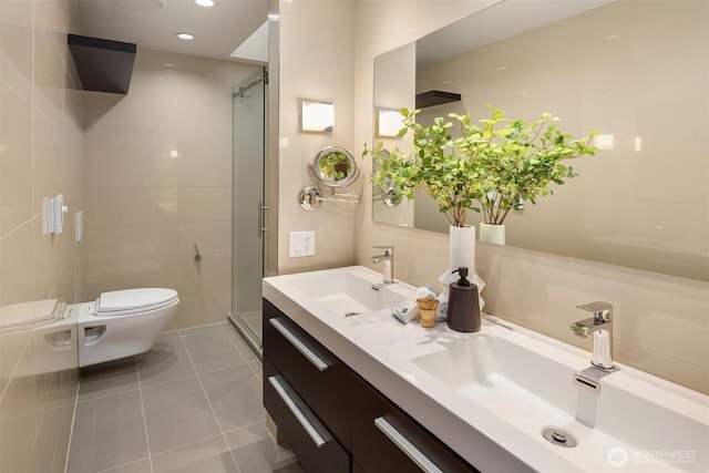 full bath with a sink, tile patterned floors, a stall shower, and toilet