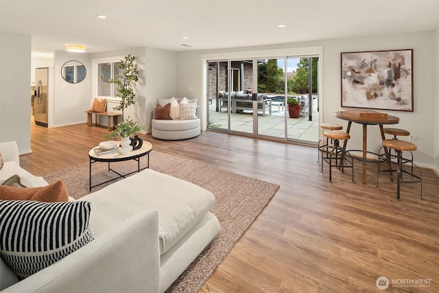 living area with recessed lighting, baseboards, and wood finished floors