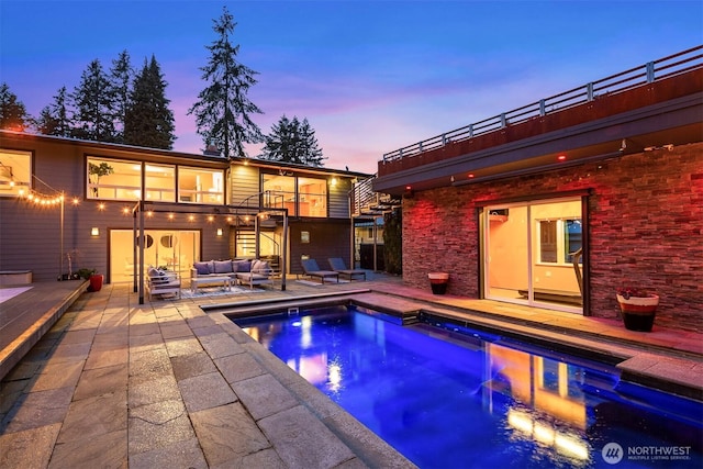 outdoor pool featuring an outdoor hangout area, a patio area, and stairway