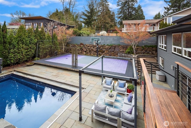 outdoor pool featuring fence, an outdoor hangout area, and a patio area