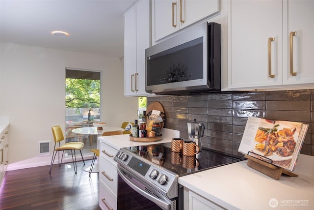 kitchen featuring light countertops, tasteful backsplash, stainless steel appliances, and visible vents
