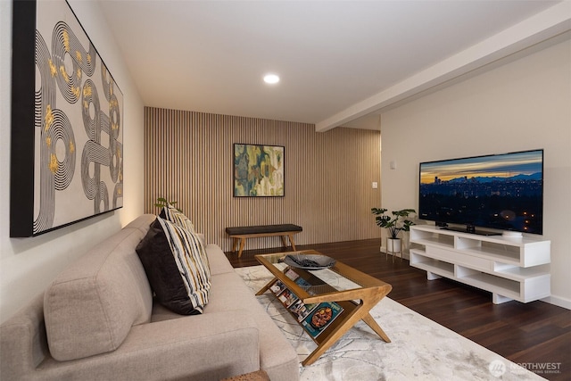 living area featuring beam ceiling, an accent wall, recessed lighting, baseboards, and wood finished floors