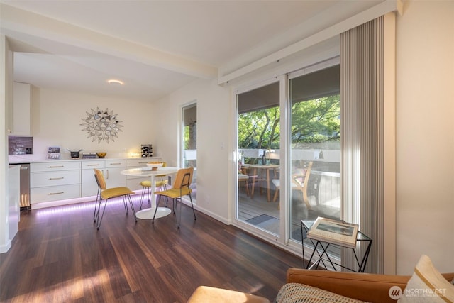 dining space featuring dark wood-type flooring and baseboards