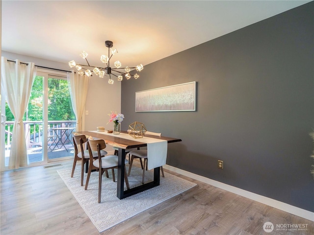 dining area featuring baseboards, a chandelier, wood finished floors, and visible vents