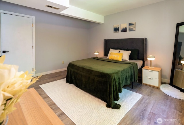 bedroom with baseboards, pool table, wood finished floors, and visible vents