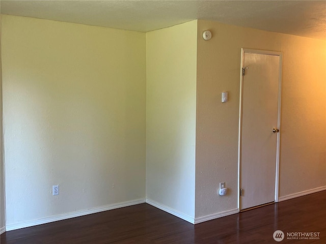 empty room with baseboards and wood finished floors