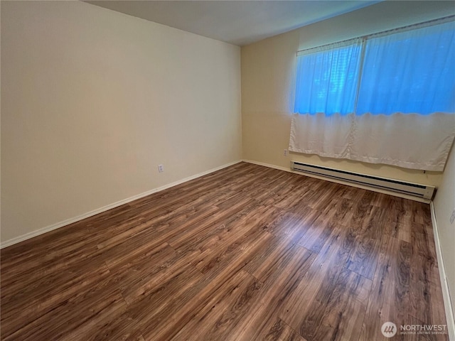 unfurnished room featuring baseboards, baseboard heating, and dark wood-type flooring