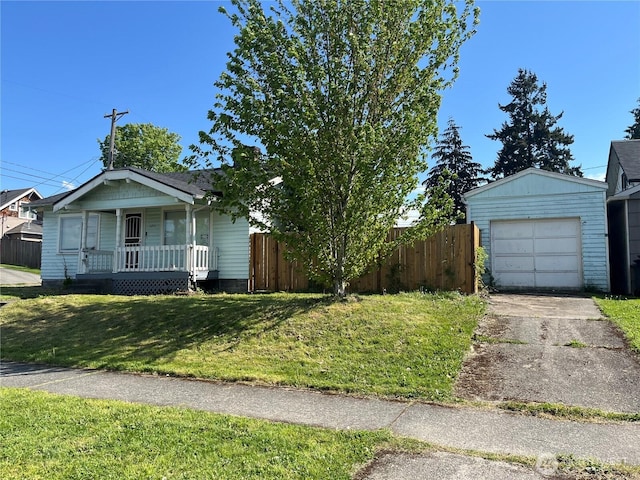 view of front of property with fence, a porch, a front yard, an outdoor structure, and driveway