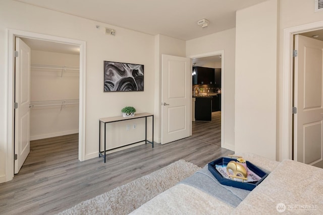 819 Virginia Unit 1104, Seattle, WA 98101 - bedroom featuring wood finished floors, a spacious closet, a closet, and baseboards