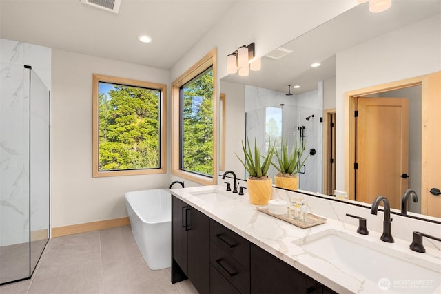 bathroom with visible vents, a marble finish shower, a sink, and a freestanding bath