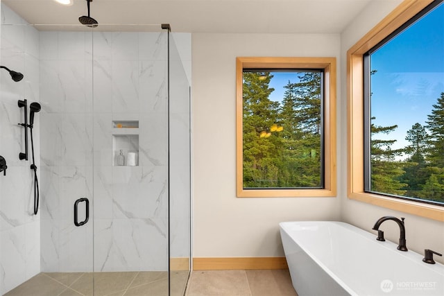 bathroom with a marble finish shower, plenty of natural light, a soaking tub, and tile patterned floors