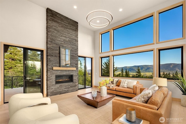 living area featuring recessed lighting, a high ceiling, a fireplace, and a mountain view