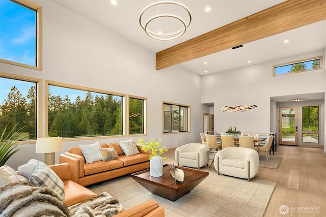 living room featuring beamed ceiling, recessed lighting, a high ceiling, and wood finished floors