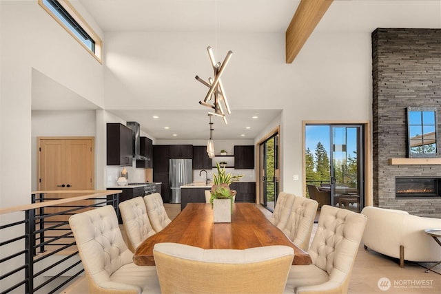 dining space with recessed lighting, a high ceiling, a fireplace, and light wood-type flooring