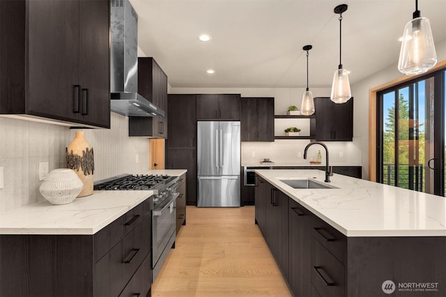 kitchen featuring open shelves, wall chimney exhaust hood, a sink, appliances with stainless steel finishes, and backsplash