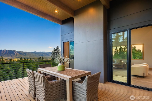 wooden terrace featuring outdoor dining area and a mountain view